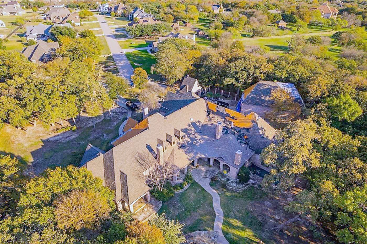 Finished shingle roof among oak trees, seen from a drone