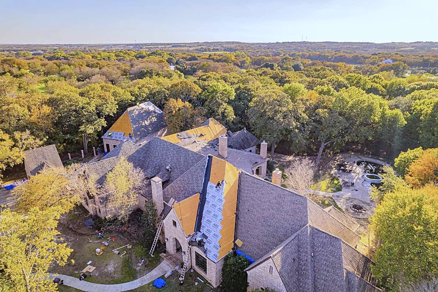 Drone view of a large roof with underlayment exposed on one section