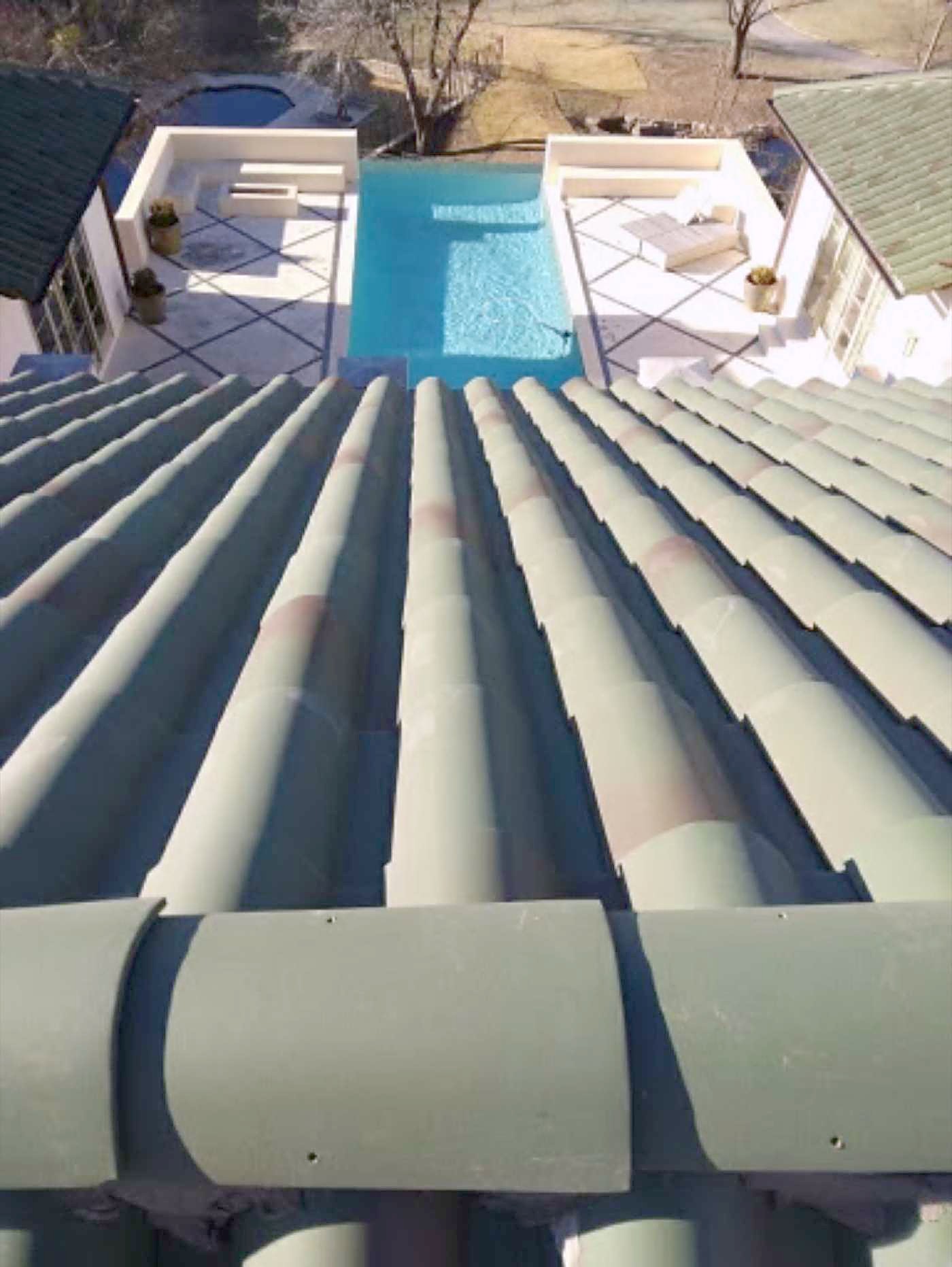 Barrel tile roof sloping down toward a backyard pool
