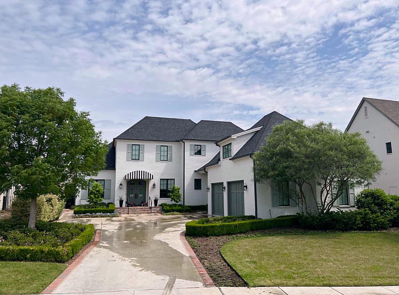 White two-story home with a dark shingle roof